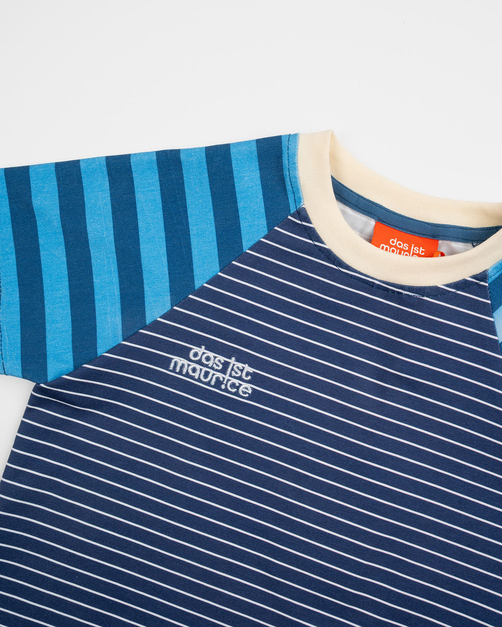 Das Ist Maurice Tshirtin Seabreeze Stripe at Cerise.  Contrasting blue and navy vertical stripes on the raglan sleeves create a fun mix of patterns and colour, giving this striped kids’ T-shirt a distinctive Das Ist Maurice finish. The combination of classic stripes and playful colour blocking makes it an easy piece to style with kids’ shorts, pants or jeans.