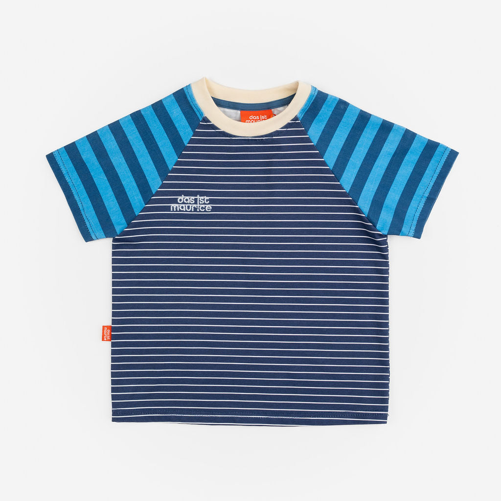 Das Ist Maurice Tshirtin Seabreeze Stripe at Cerise.  Contrasting blue and navy vertical stripes on the raglan sleeves create a fun mix of patterns and colour, giving this striped kids’ T-shirt a distinctive Das Ist Maurice finish. The combination of classic stripes and playful colour blocking makes it an easy piece to style with kids’ shorts, pants or jeans.