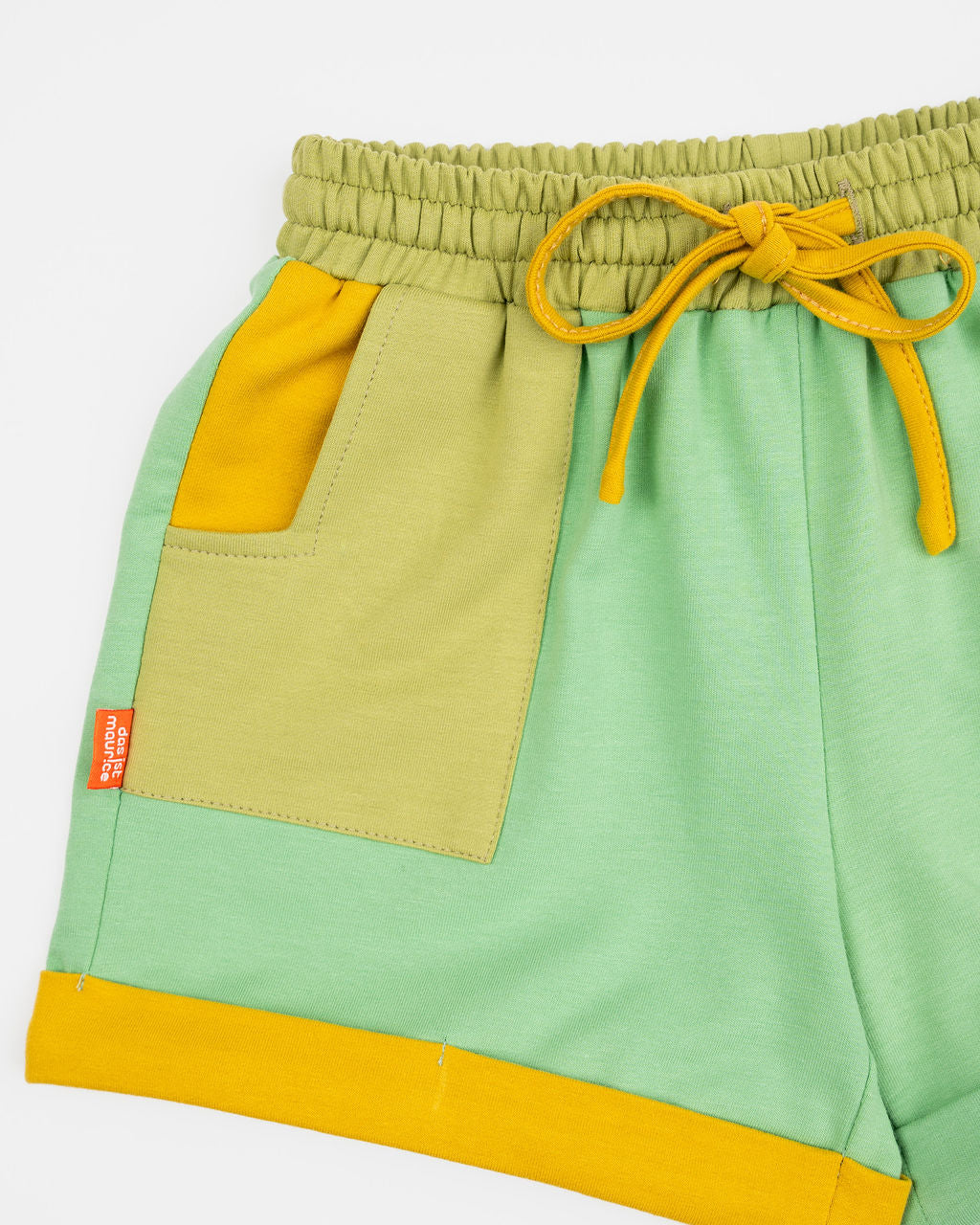 Das Ist Maurice Shorts in Meadow at Cerise. Made from 100% cotton in soft green with  Contrasting pockets, mustard yellow drawstring and rolled cuffs .