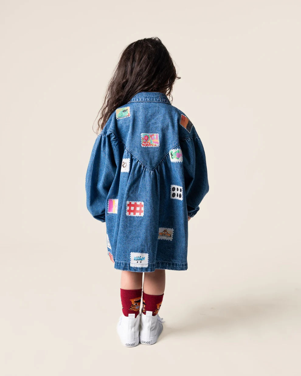 Das Ist Maurice Denim Smock Dress with long sleeves, front patch pockets, button front, collar and gathered yoke at the front with a V shaped gathered yoke at the back. Has a patchwork stamp pattern on the fabric at Cerise NZ