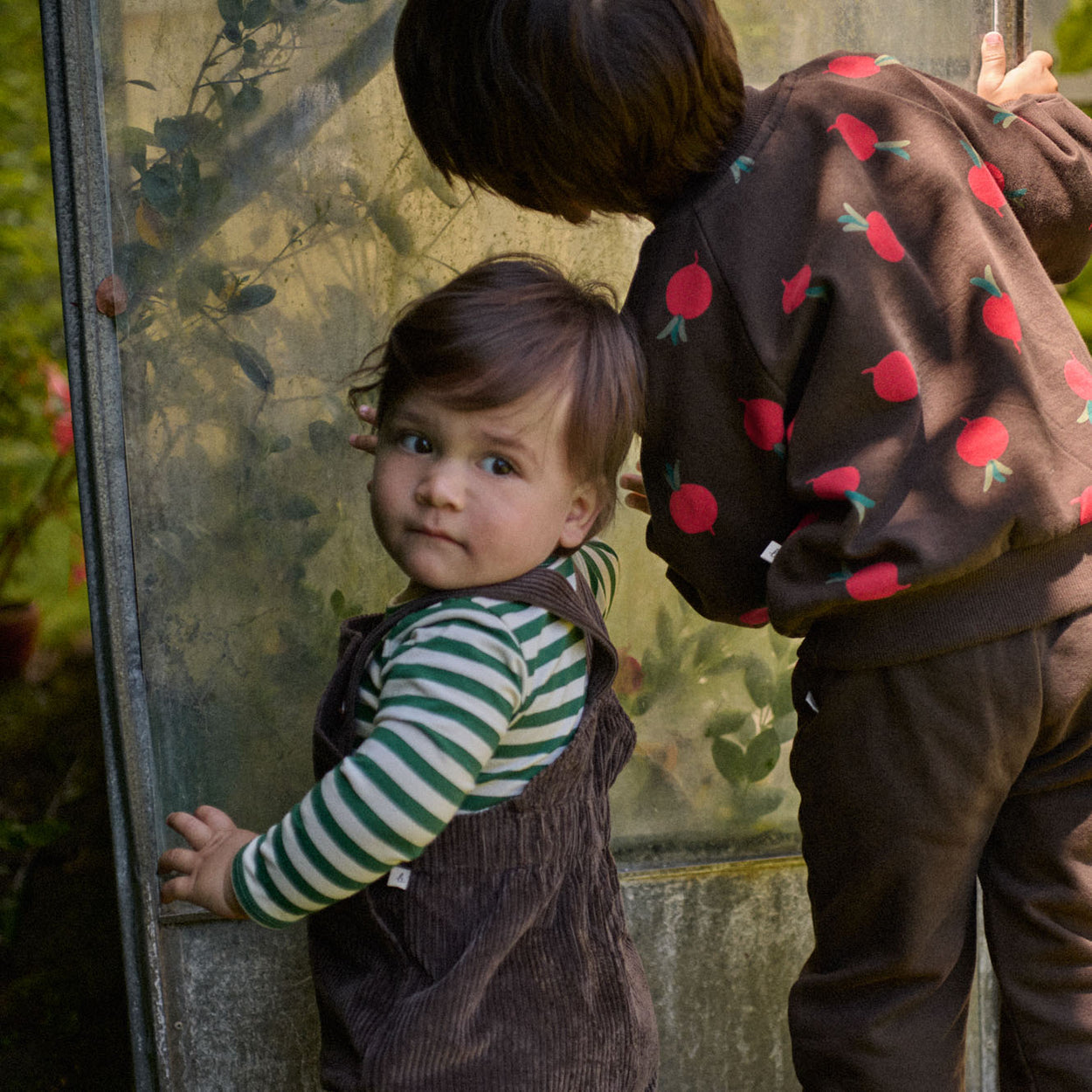 Nature Baby Emerson Sweater in Brown cotton knit with radish print in red and green. Nature Baby  at Ceriseeddy overallin in Pincone colour teamed with Eden stripe Bodysuit at Cerise