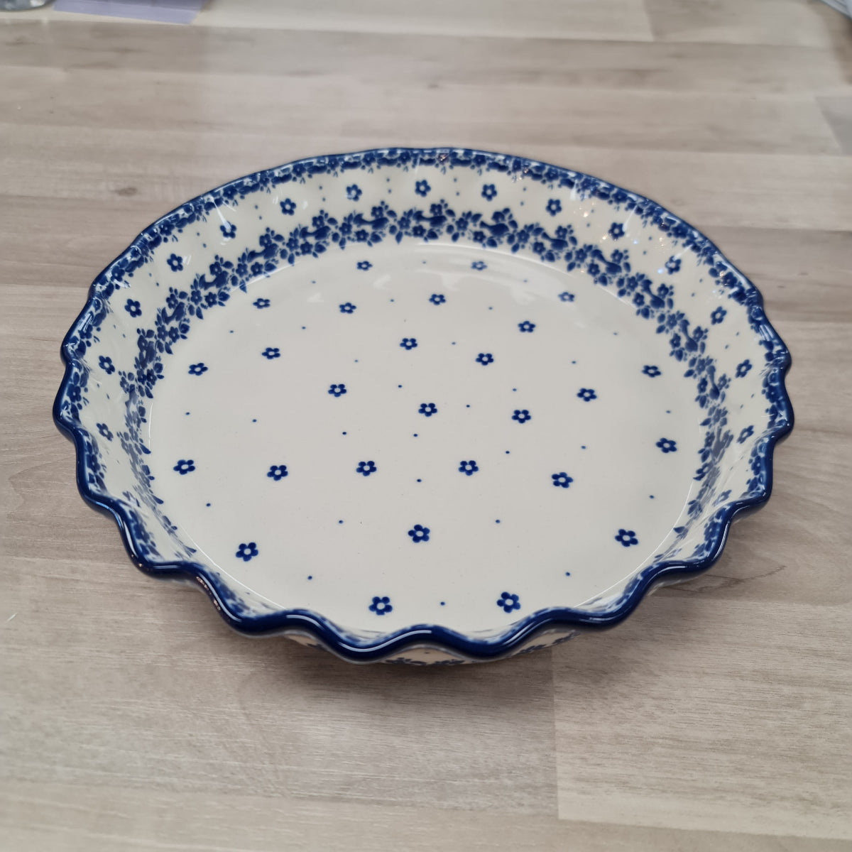Ceramic plate with blue floral pattern on a wooden surface