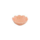Pink ceramic bowl with scalloped edge on a white background