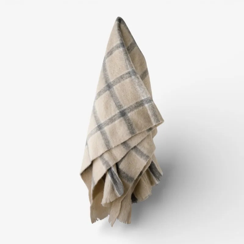 Juniper Throw from French Country Collections at Cerise. Featuring Grey Check stripes on a neutral background and tassle ends.