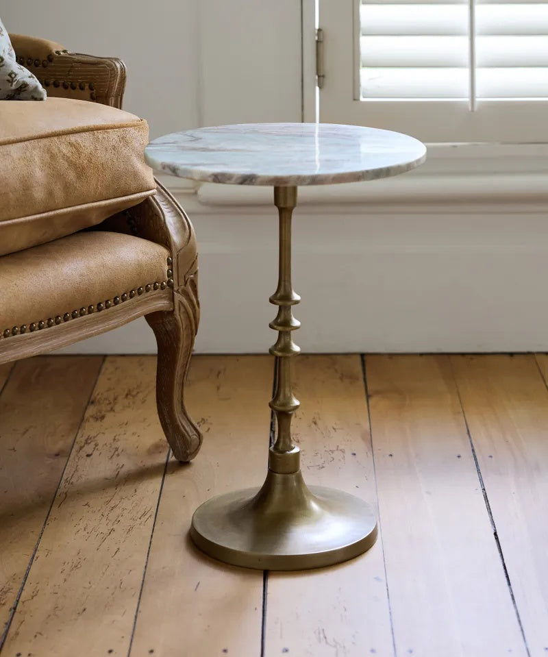 Elevate your living space with the Sutton Side Table from French Country at Cerise. Featuring a timeless antique gold metal base paired with a beautifully veined natural marble top in warm, earthy tones. Blending classic elegance with contemporary style, this versatile piece is perfect beside a sofa, armchair, or bed.