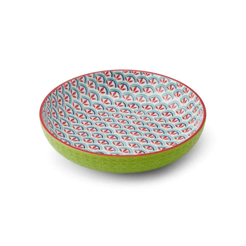 Colorful ceramic bowl with a blue and red pattern on green reverse on a white background