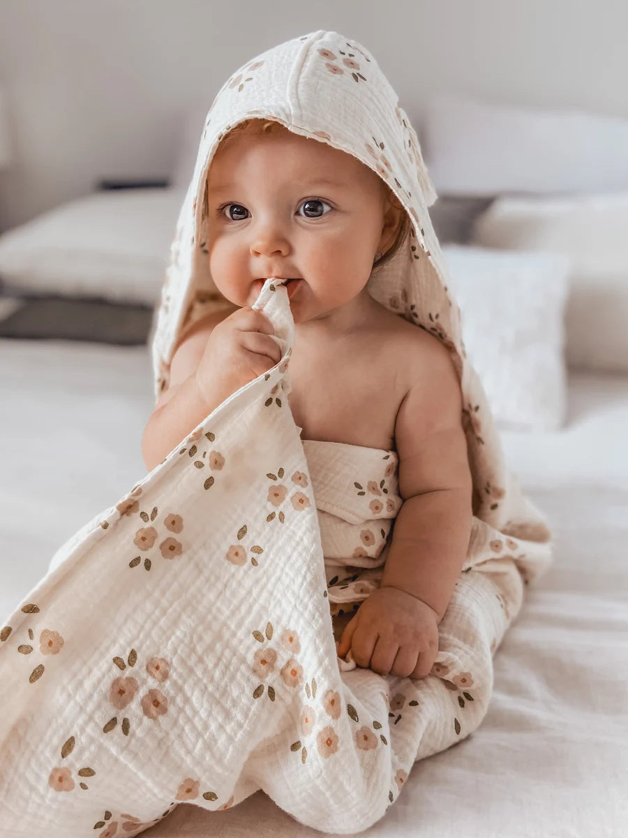 Over the Dandelions Hooded Towel in Daisy Print at Cerise. Made from super soft cotton muslin, has a hood and plenty of wrap for baby.