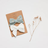 Overe the Dandelions Set of 2 Muslin Bow Hair Clips at Cerise.  Includes one ivory colour and one sofet green with daisy print clip for girs.