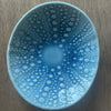 Blue kina ceramic bowl with bubble pattern on a wooden surface