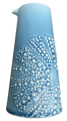Blue ceramic kina jug with white bubble texture on a white background