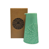 Aqua coloured ceramic handleless jug with embossed kina design