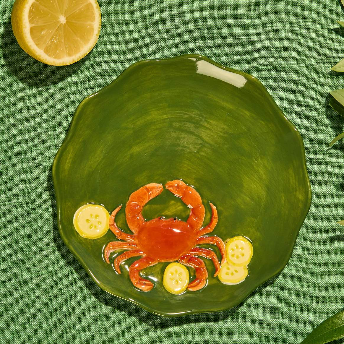 Close-up of the raised crab design on a green glazed stoneware plate at Cerise