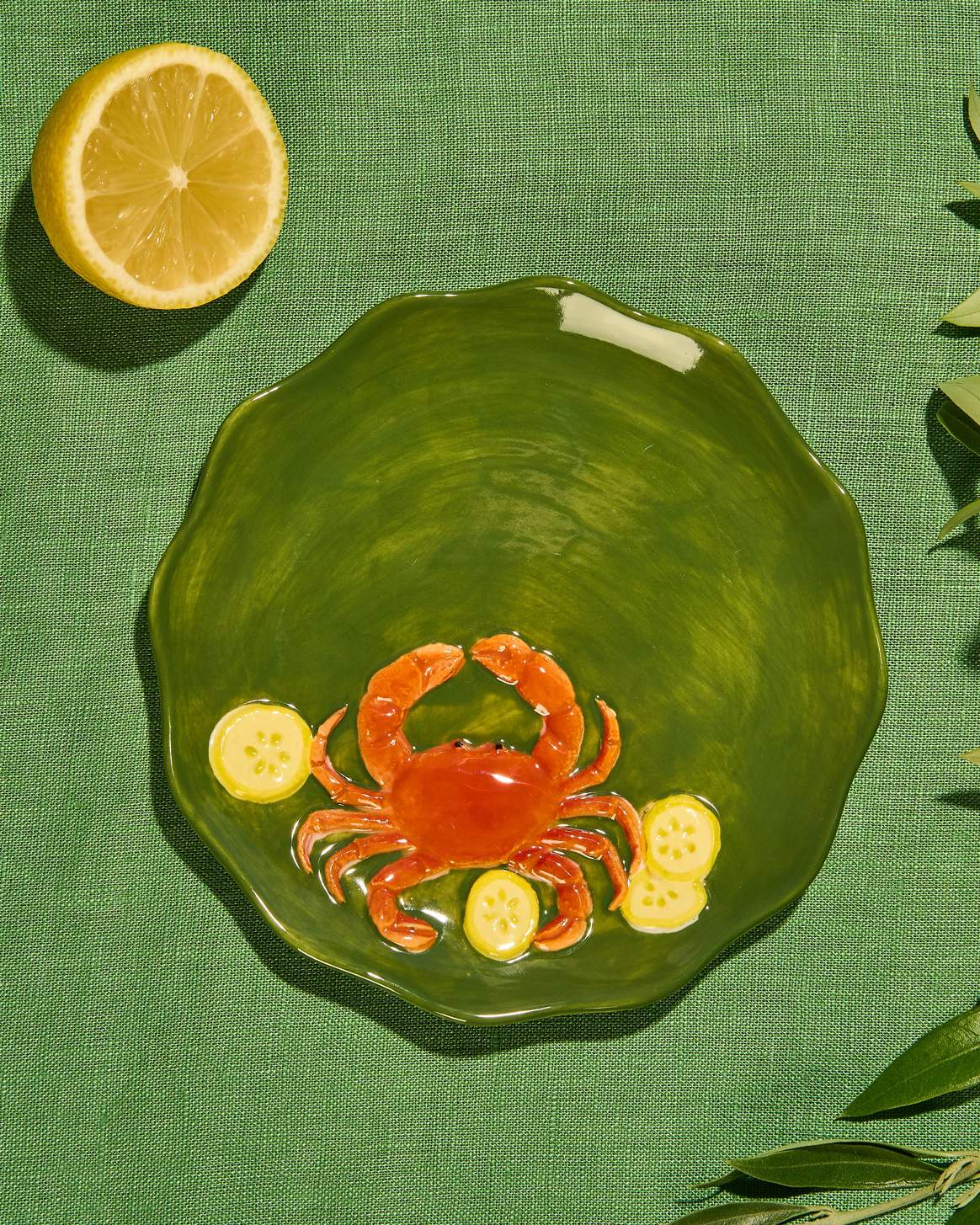 Close-up of the raised crab design on a green glazed stoneware plate at Cerise