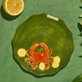 Close-up of the raised crab design on a green glazed stoneware plate at Cerise