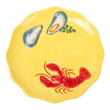 Close-up of raised lobster and shell design on a yellow glazed stoneware plate at Cerise