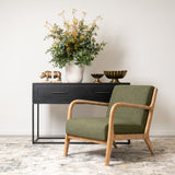 Dark Green Luca ocassional chair with whitewashed arms in a lounge setting beside a black console with gold decor