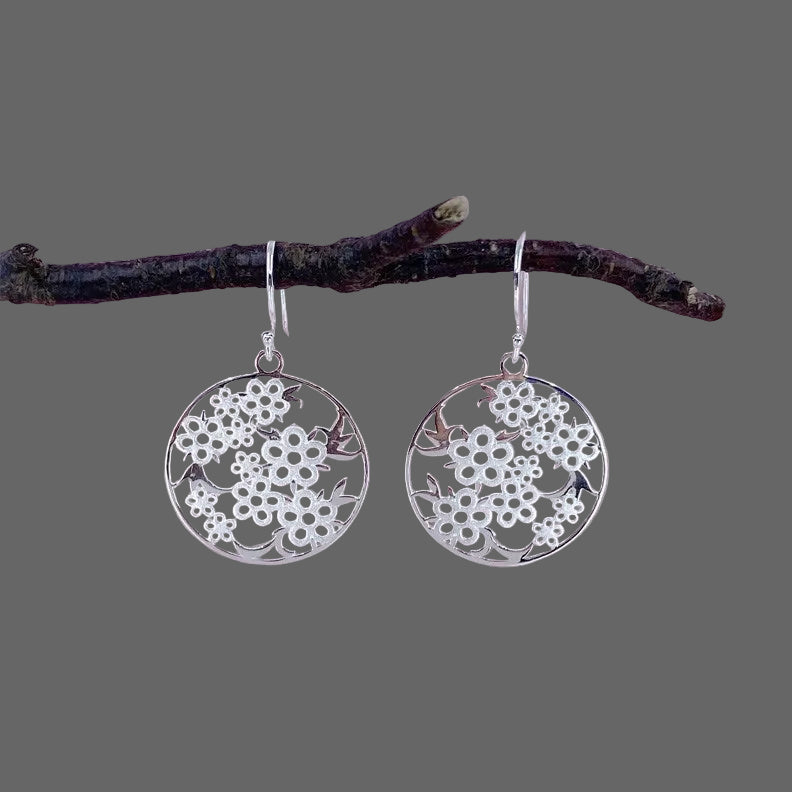Silver drop earrings with a NZ Manuka Flower design, hanging on a sterling silver hook.