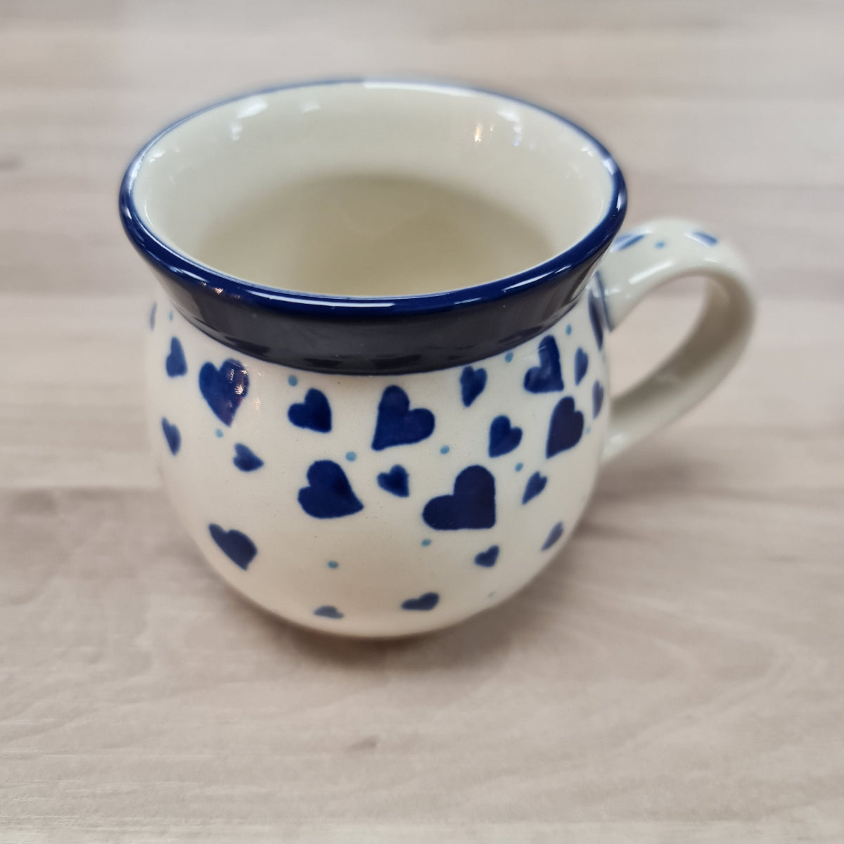 Cream round pottery mug with blue hearts