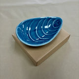 Blue mussel shaped bowl on cardboard box
