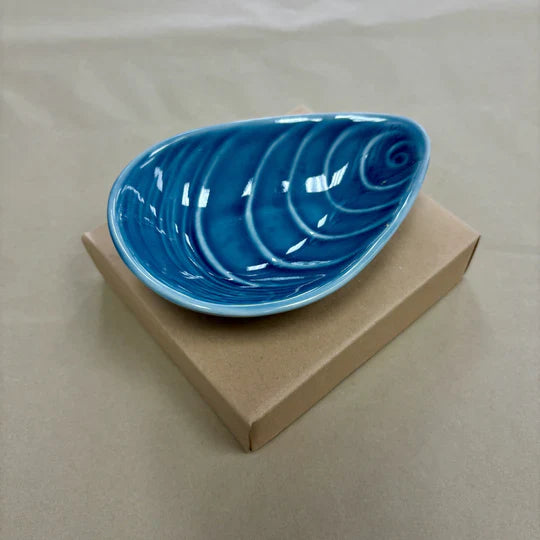 Blue mussel shaped bowl on cardboard box