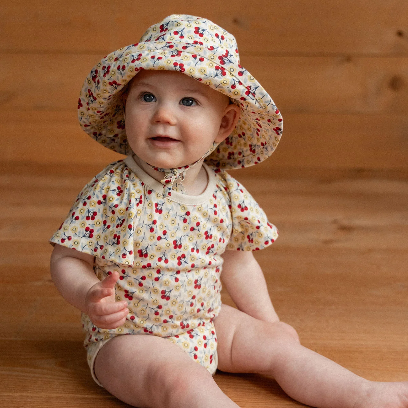 Nature Baby Faye Bodysuit in Kitchen Garden Print with flutter sleeves at Cerise