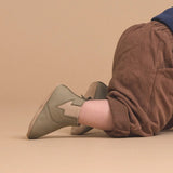 Concept photo of baby wearing Pretty Brave Electric Baby Shoe in olive colour at Cerise. Made from soft leather with suede lining and soft sole.