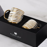 Two gold and white striped mugs in a black Pampa Bay box 