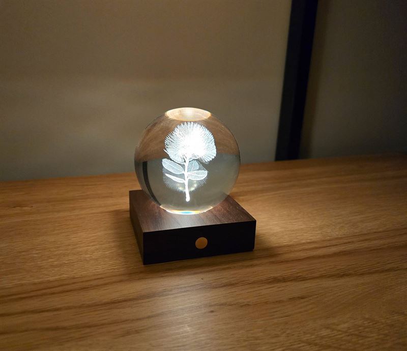 Crystal ball light with laser engraved phohutukawa flower.