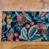 Decorative doormat in a pohutakawa and kowhai design in dark blue, teal , green, red and yellow tones