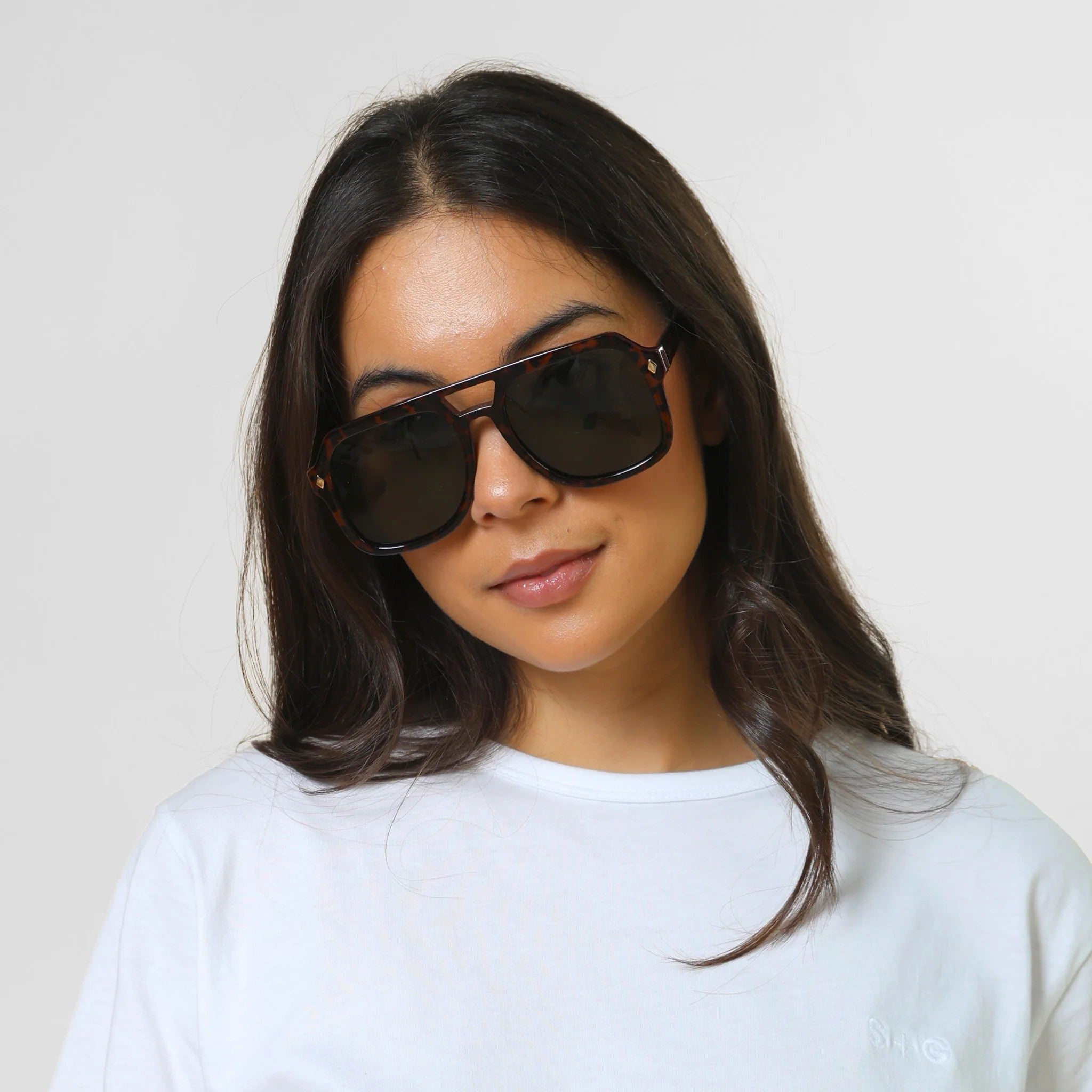 Woman wearing tort and black sunglasses with a large square frame
