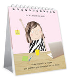 Desk calendar with illustration of a person at a desk and humorous text on a pink background