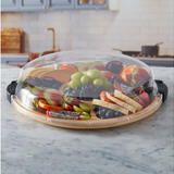 Fruit and vegetable platter with a dome cover on a marble countertop