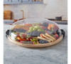 Fruit and vegetable platter with a dome cover on a marble countertop