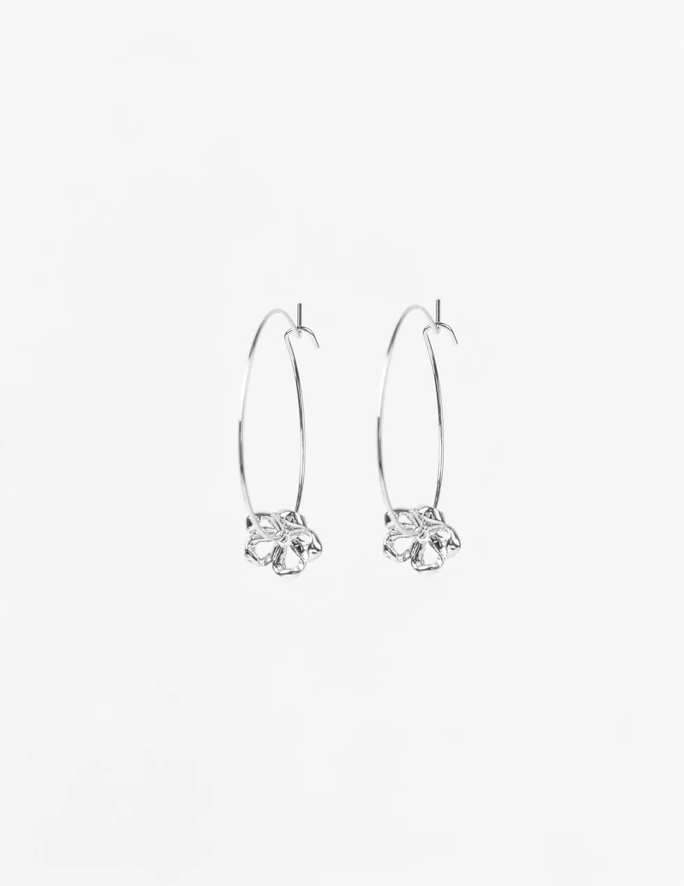 Pair of silver hoop earrings with floral designs on a white background