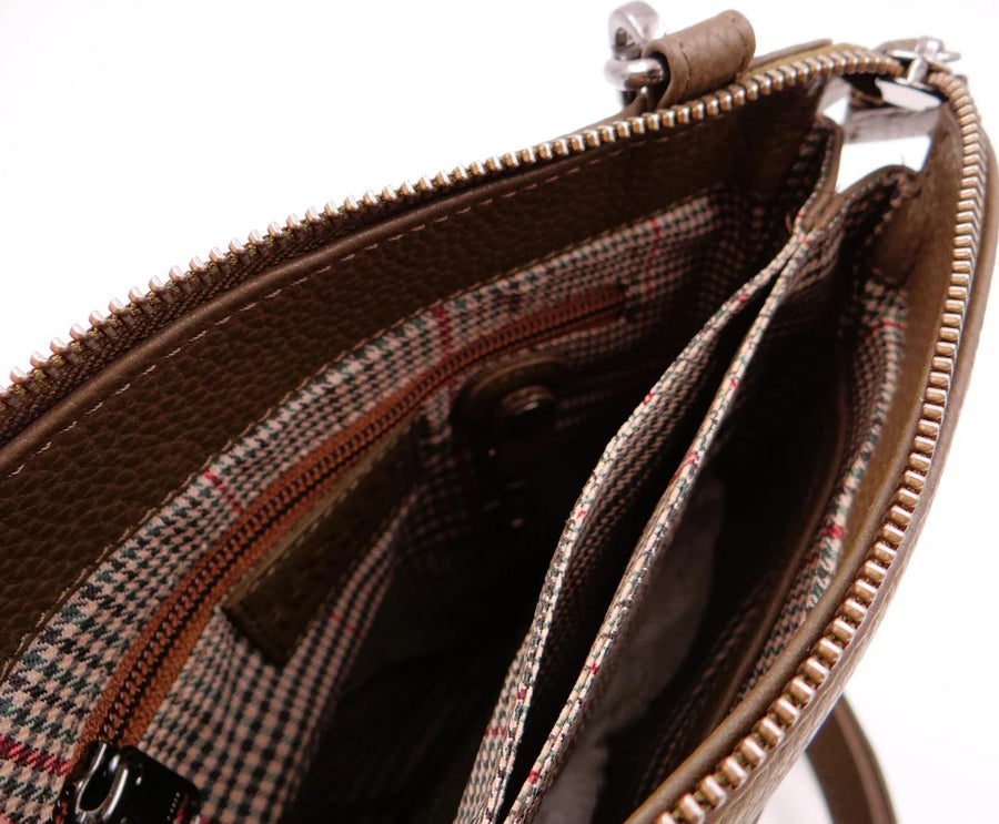Close-up of a brown leather handbag with a zipper, showing the interior.