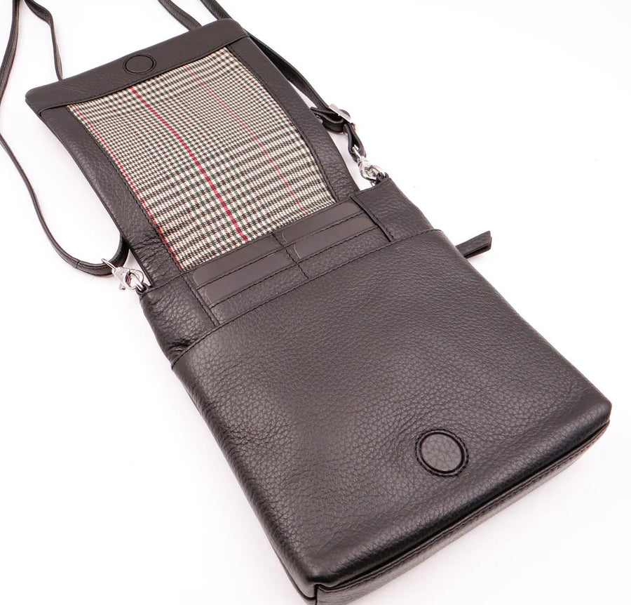 Black leather crossbody bag with plaid interior on a white background