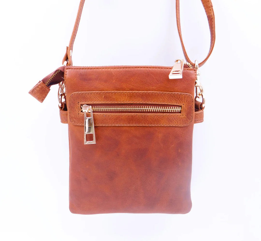 Tan leather crossbody bag with gold zipper on a white background