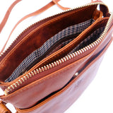 Tan leather inside lining of handbag with a zipper on a white background