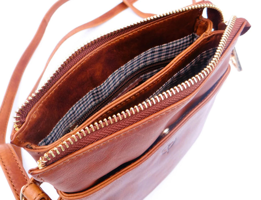 Tan leather inside lining of handbag with a zipper on a white background