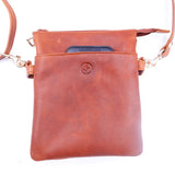 Tan leather crossbody bag with a phone pocket on a white background