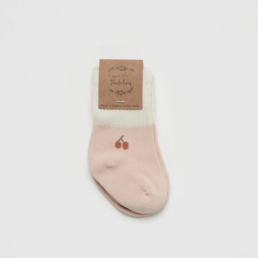 Over the Dandelions Set of 2 Baby Socks insoft blush pink and Ivory with a cherry motif design at Cerise. Made from soft organic cotton to fit newborn babies size 0 to 6 months.