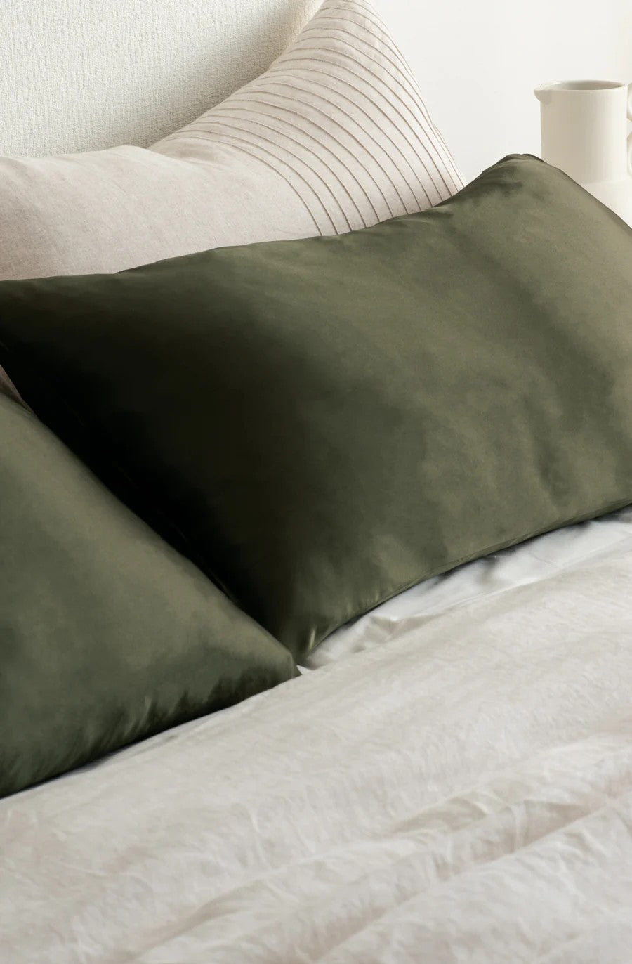 Olive green silk pillowcase on bed