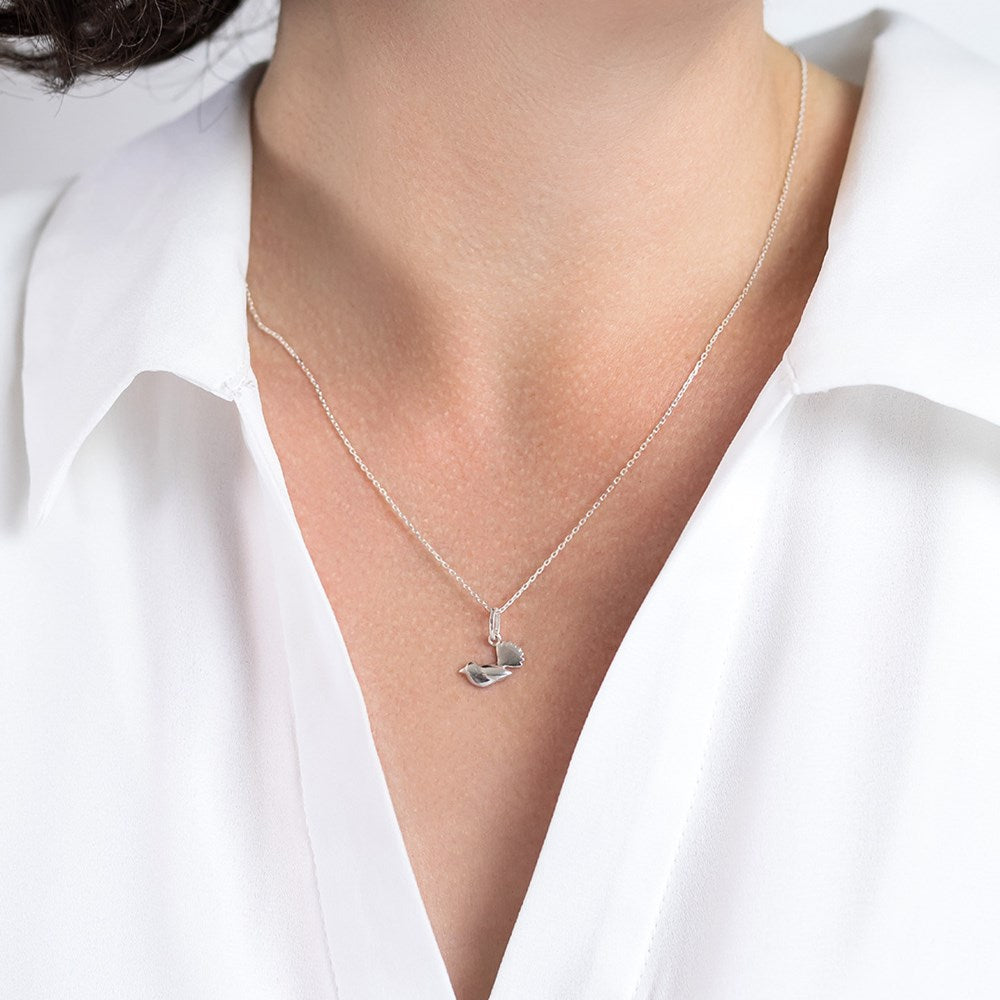 Model wearing a silver necklace with a small fantail pendant and 45cm silver chain