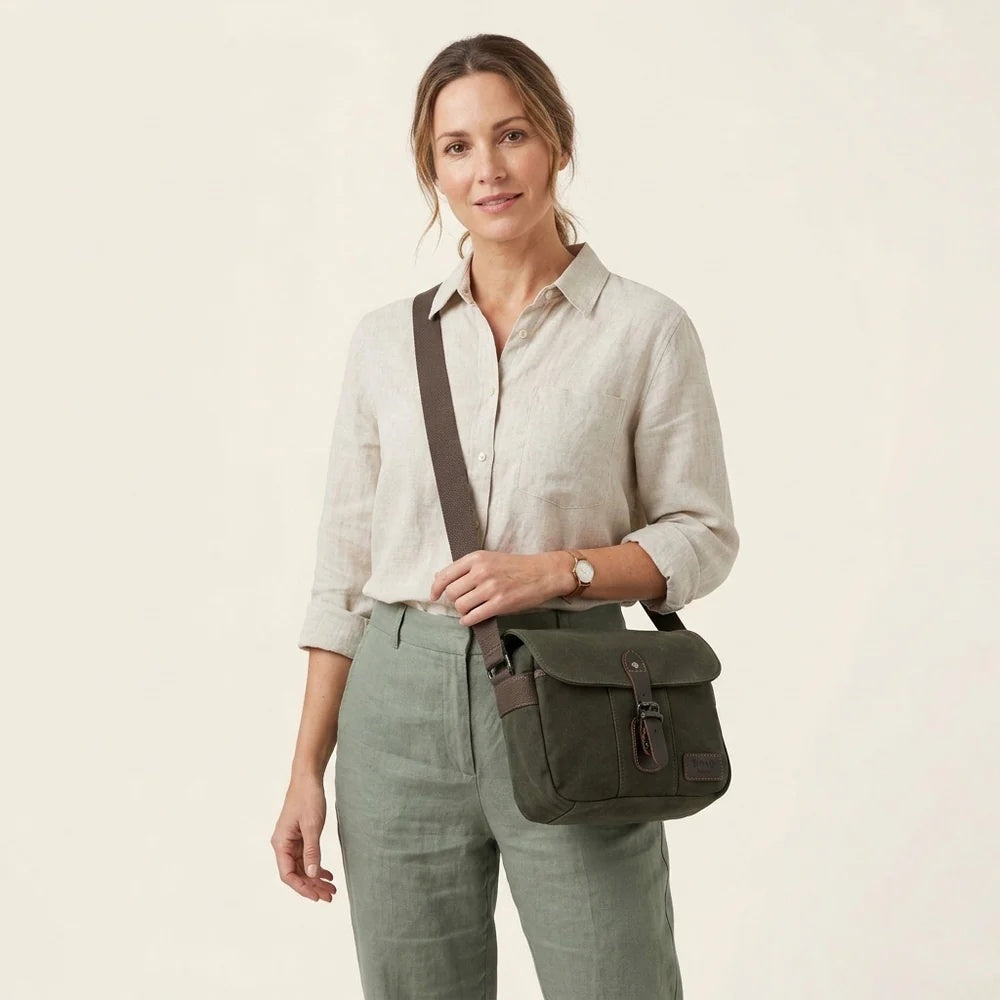 Troop London Nomad 440 Cross Body Bag at Cerise. Fully lined small travel bag with deep compartments, zip closure and phone compartment. Zip enclosure on back of bag. Measures H21 x W26 x D10cm. Made of waxed canvas, shown here in dark green.