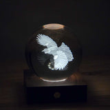 Crystal ball with engraved tui bird design 