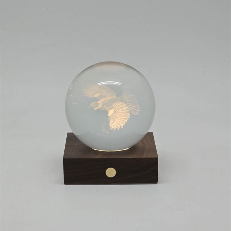 Crystal ball with an engraved tui 