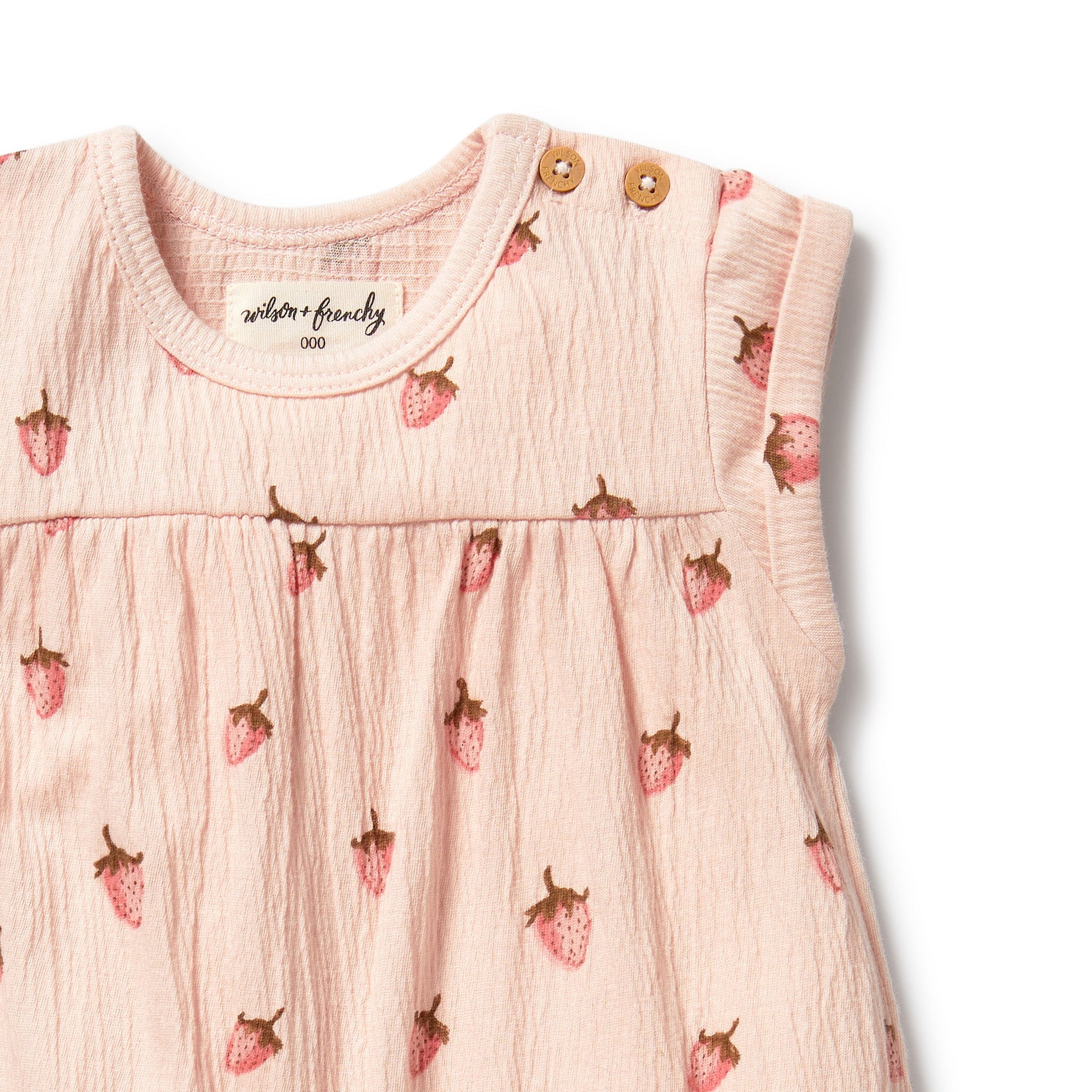 Soft pink with strawberry print all in one grow suit with short sleeves - close up of neckline showing shoulder buttons