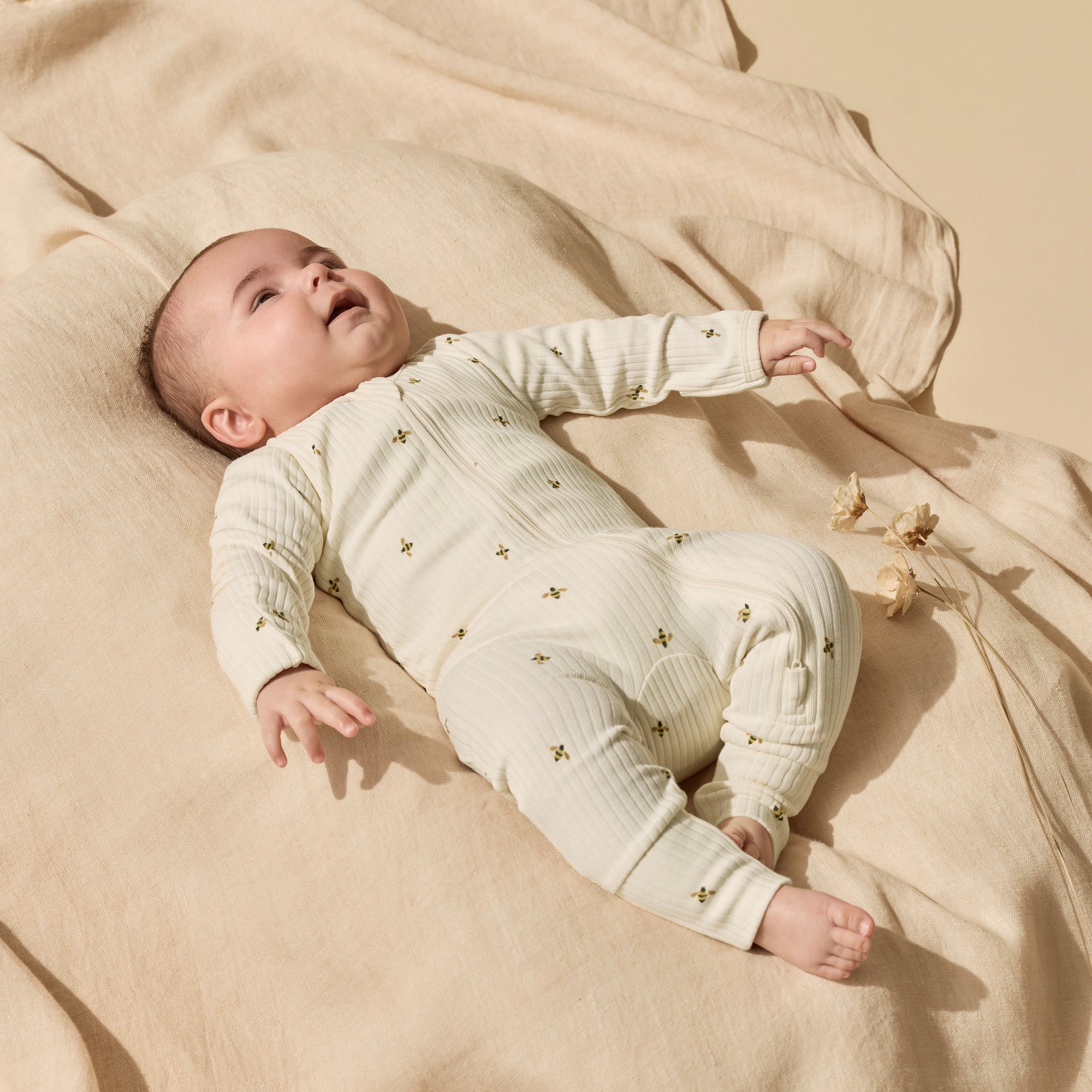 Baby wearing bee patterned onsie