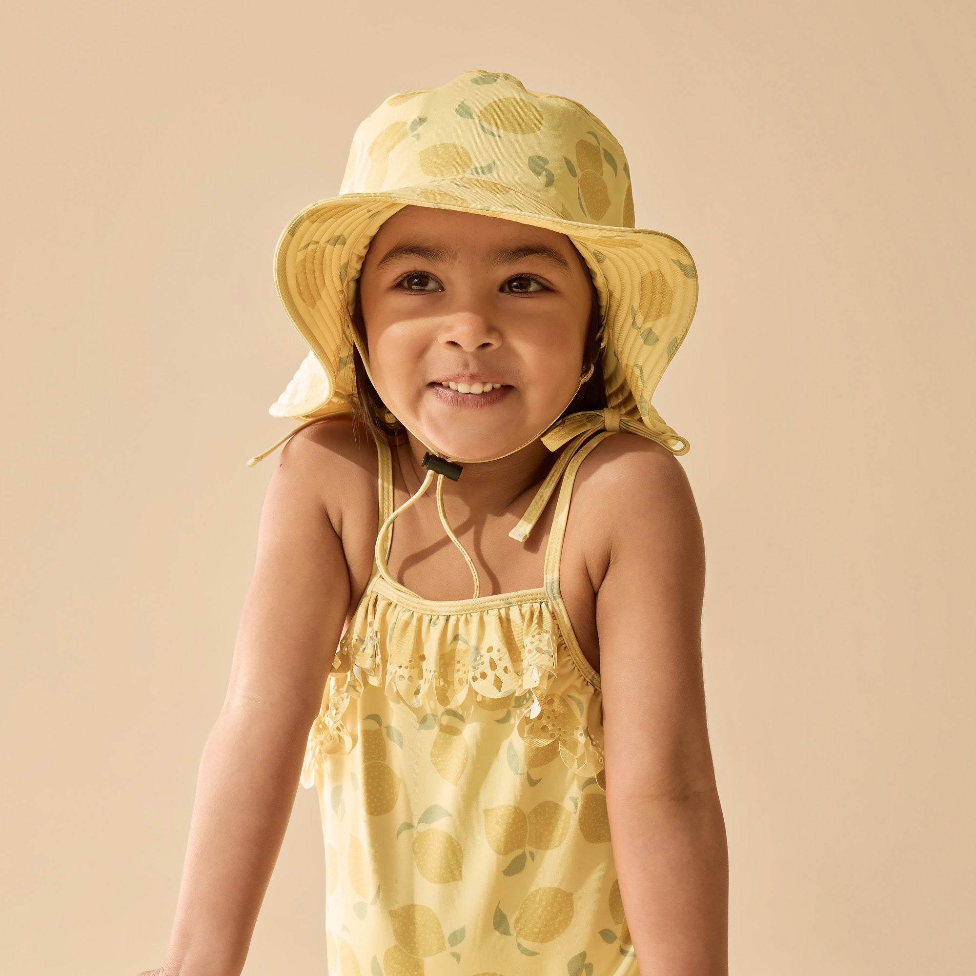 Girl wearing Yellow swim hat with lemon pattern 