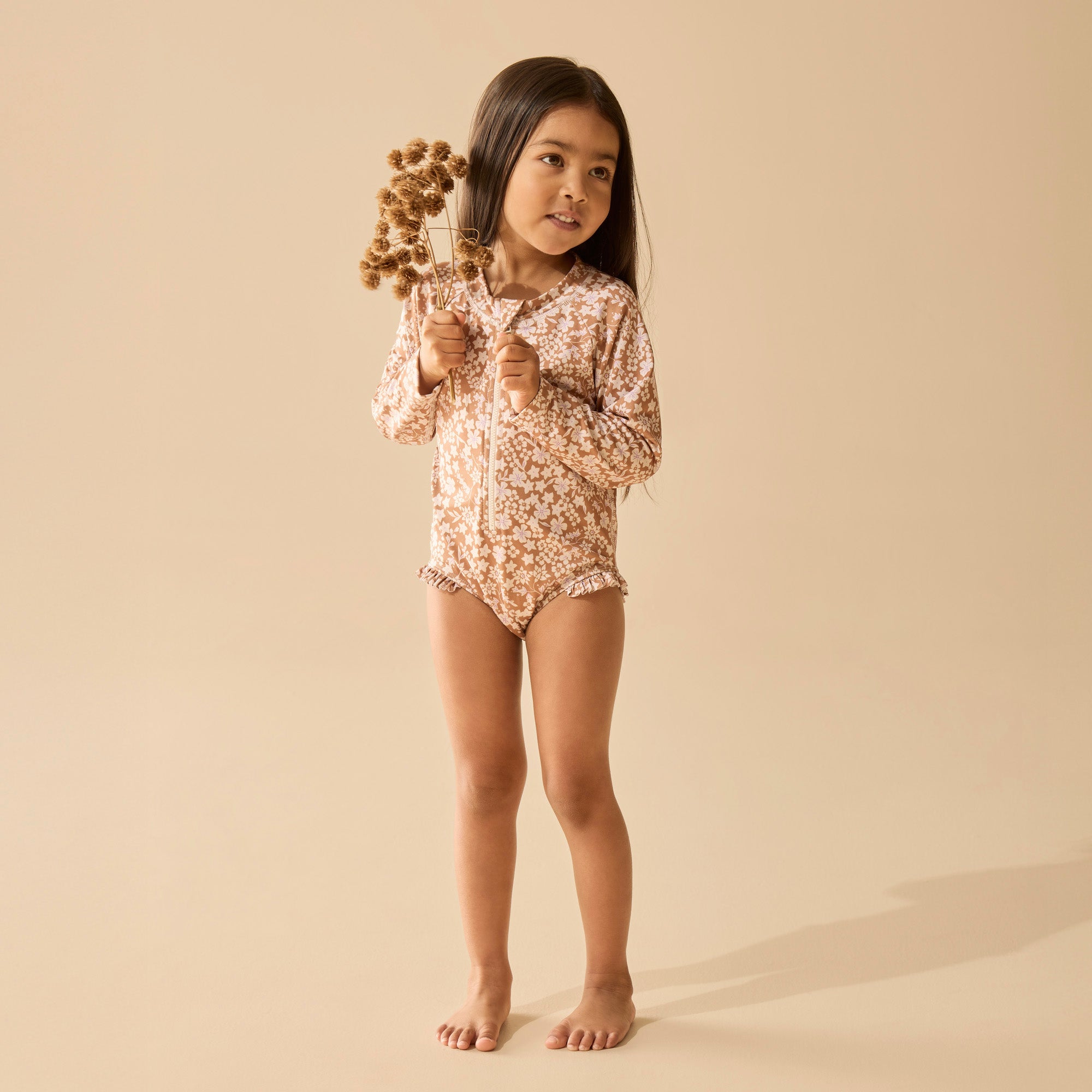 Girl wearing Floral pattern on brown background long sleeved swimsuit or girls